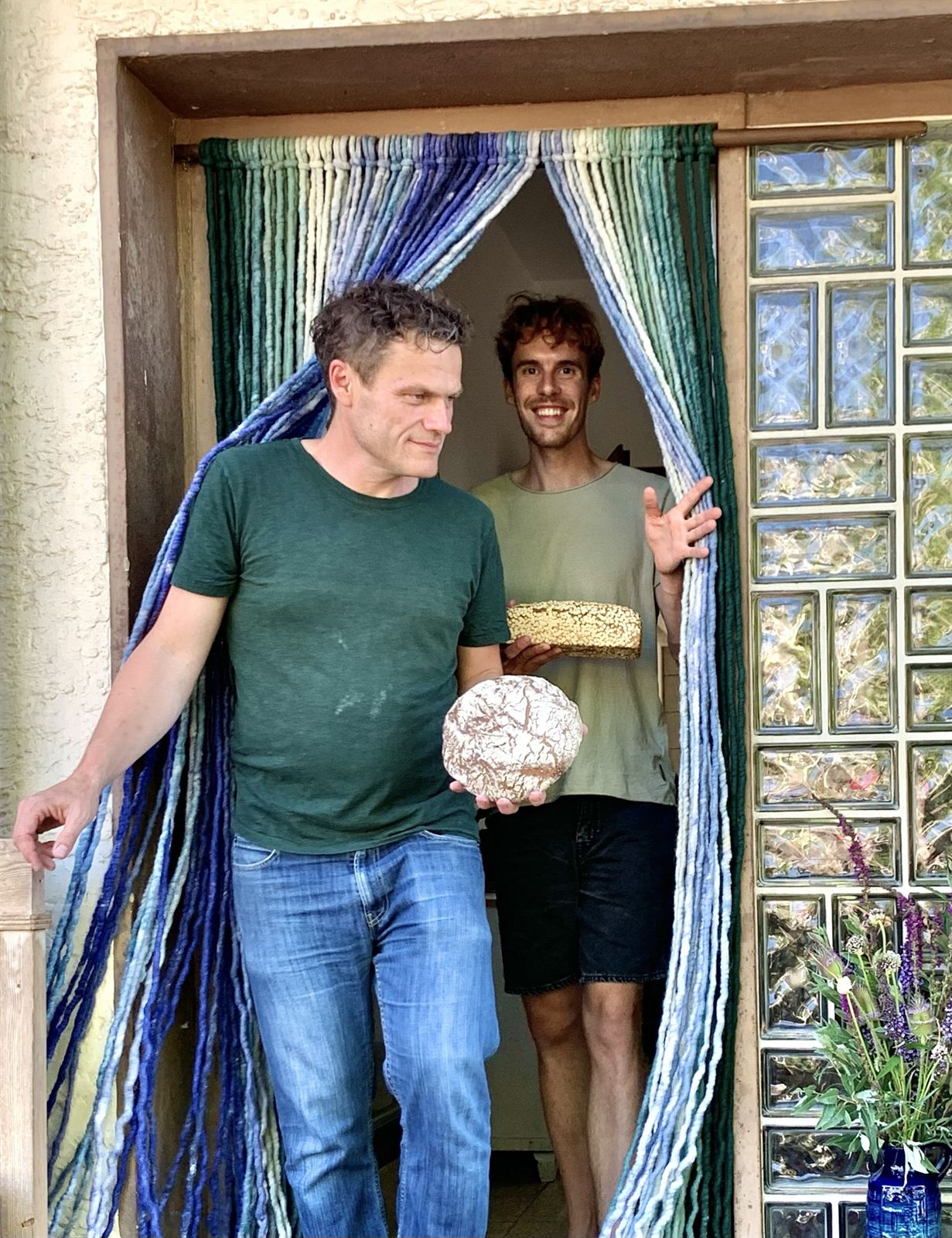 Zwei Bäcker der Regionalfabrik mit frisch gebackenen Broten in der Tür der Backstube